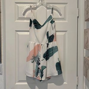 Tropical pattern romper with a cris-cross back.